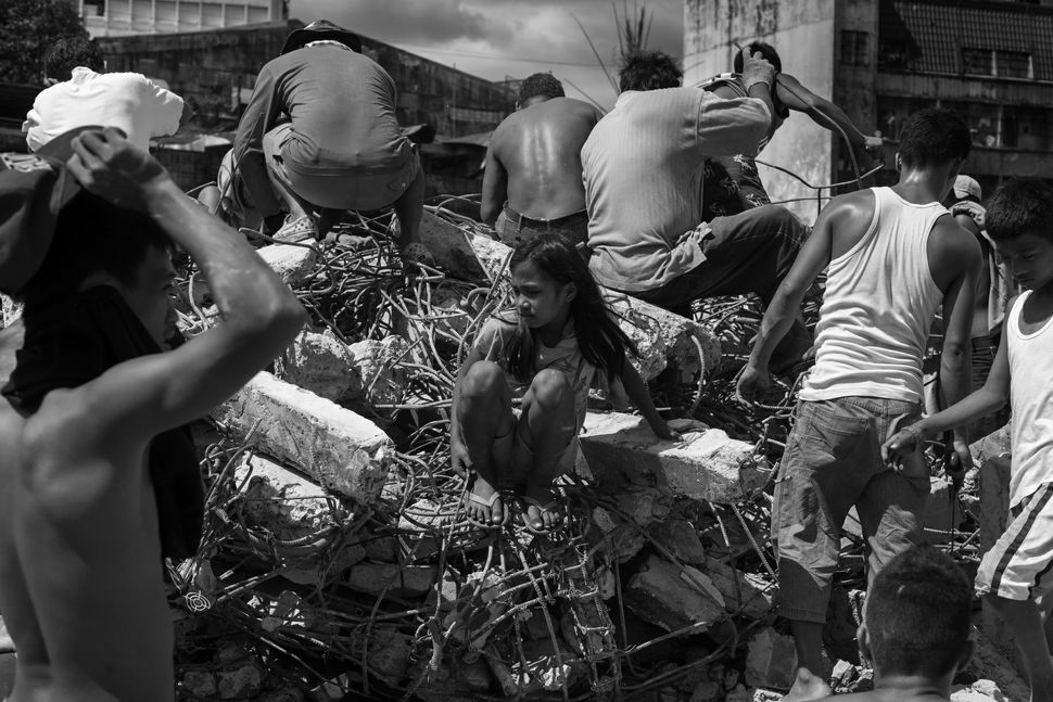 Girl among men on heap of debris